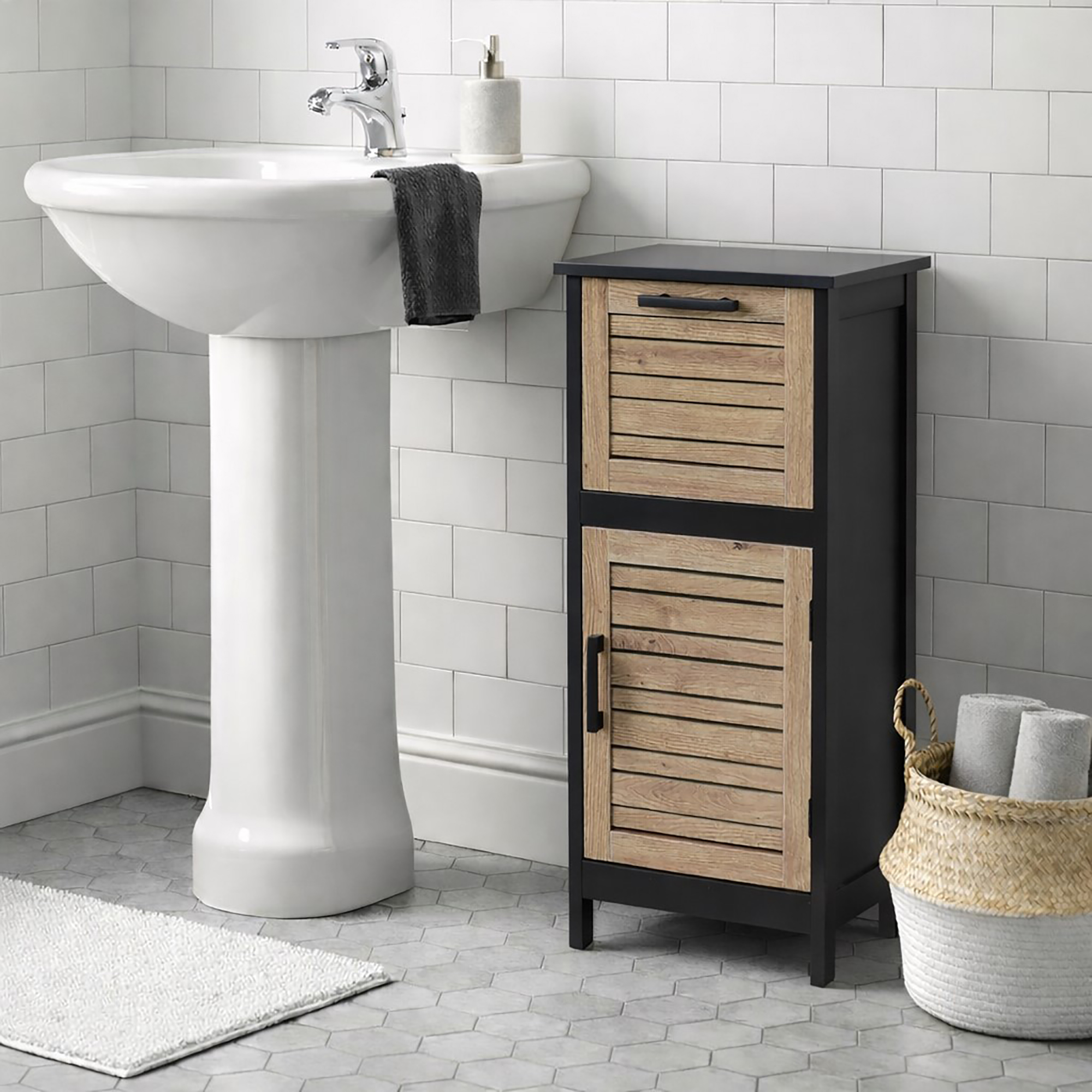 "Black and oak louvered bathroom cabinet beside a pedestal sink in a white tiled bathroom"