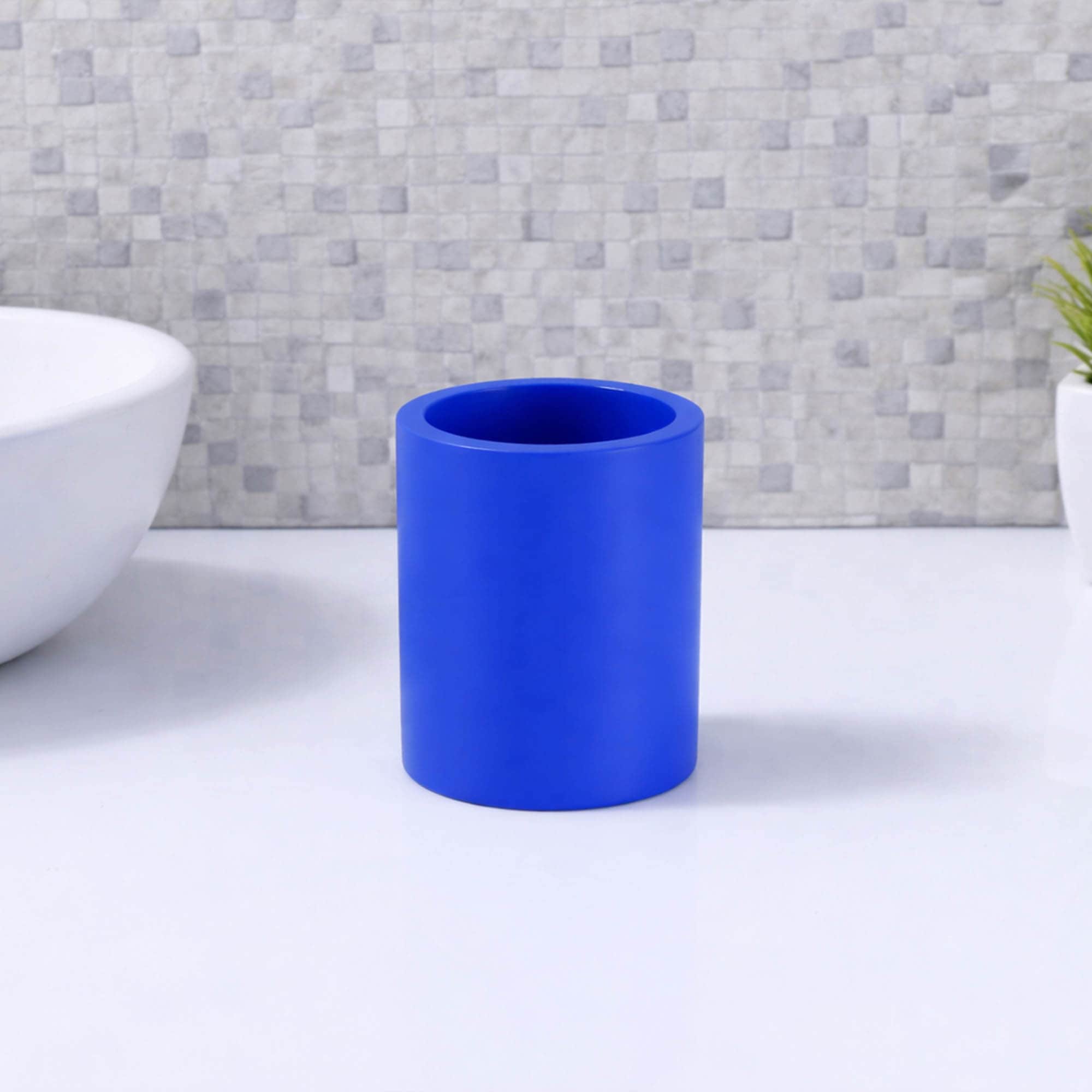 Matte blue toothbrush holder on white bathroom sink minimal setup