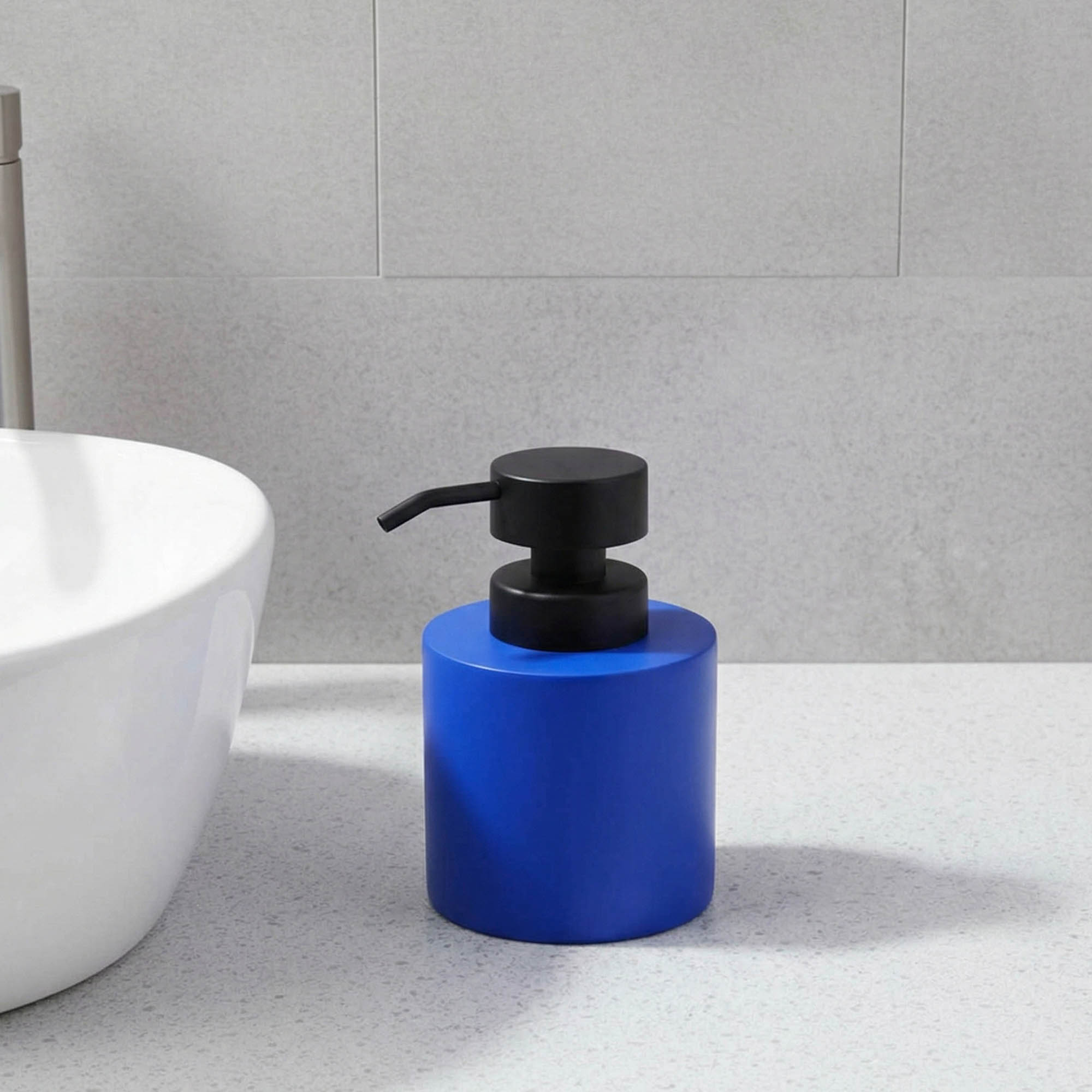 Blue soap dispenser with black pump on bathroom vanity close-up