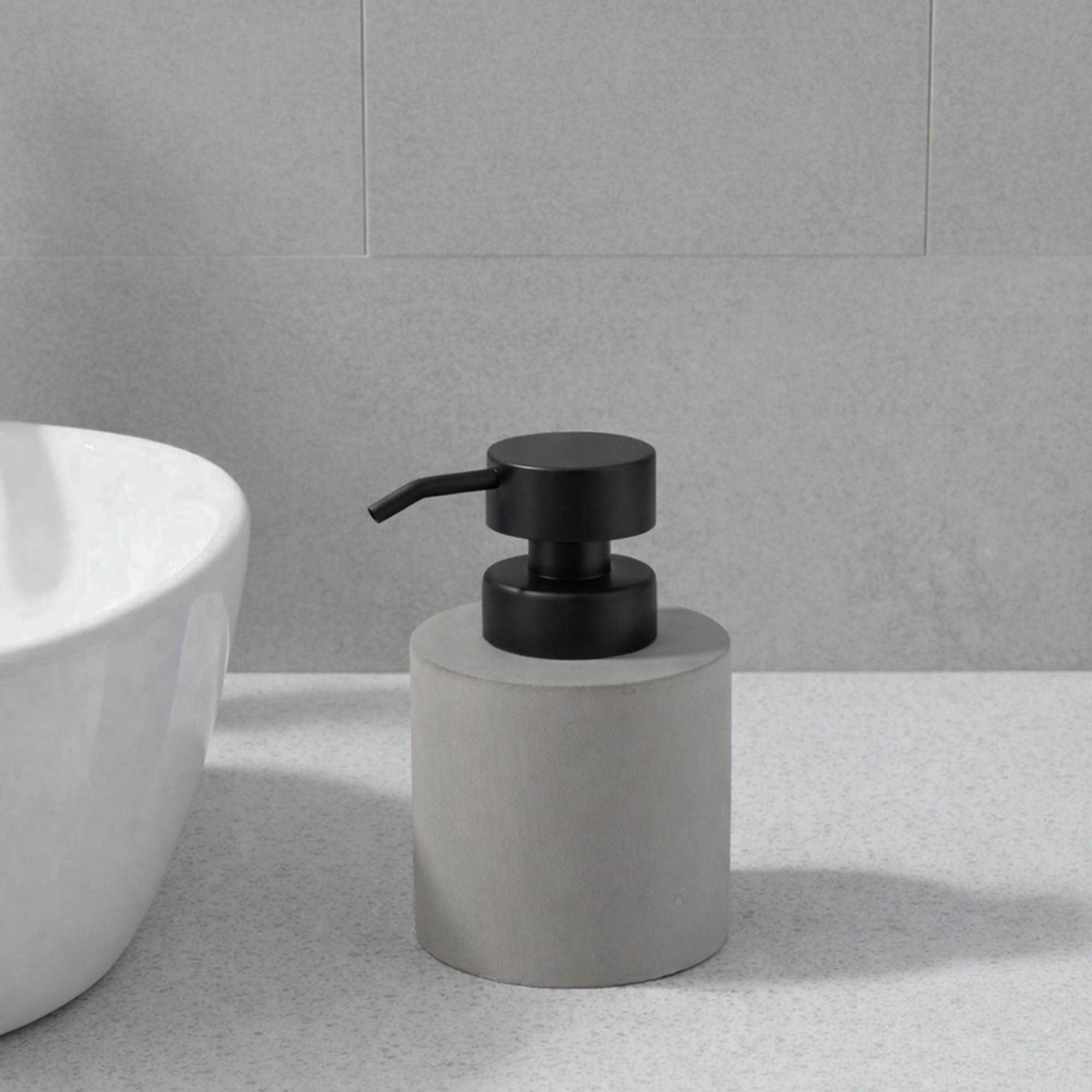 Gray soap dispenser with matching accessories on clean countertop