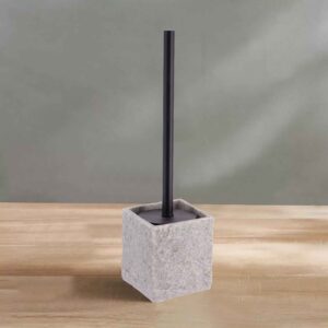 A gray stone-effect toilet brush holder from the accessory set, displayed on a wooden surface against a soft green wall.