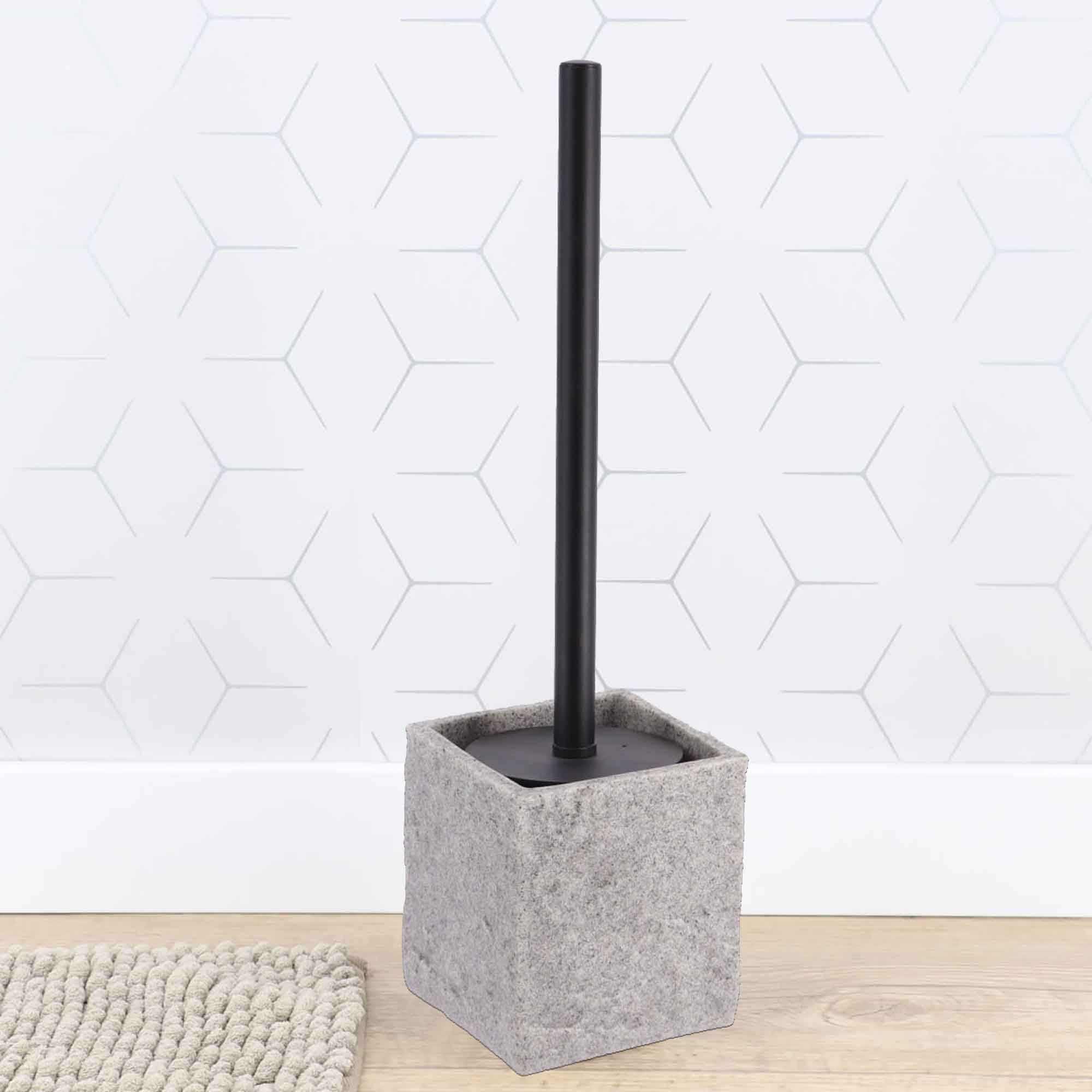 Gray stone effect toilet brush holder against white hexagonal tile wall
