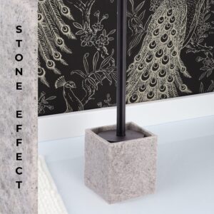 Gray stone effect toilet brush holder on bathtub edge with peacock wallpaper background
