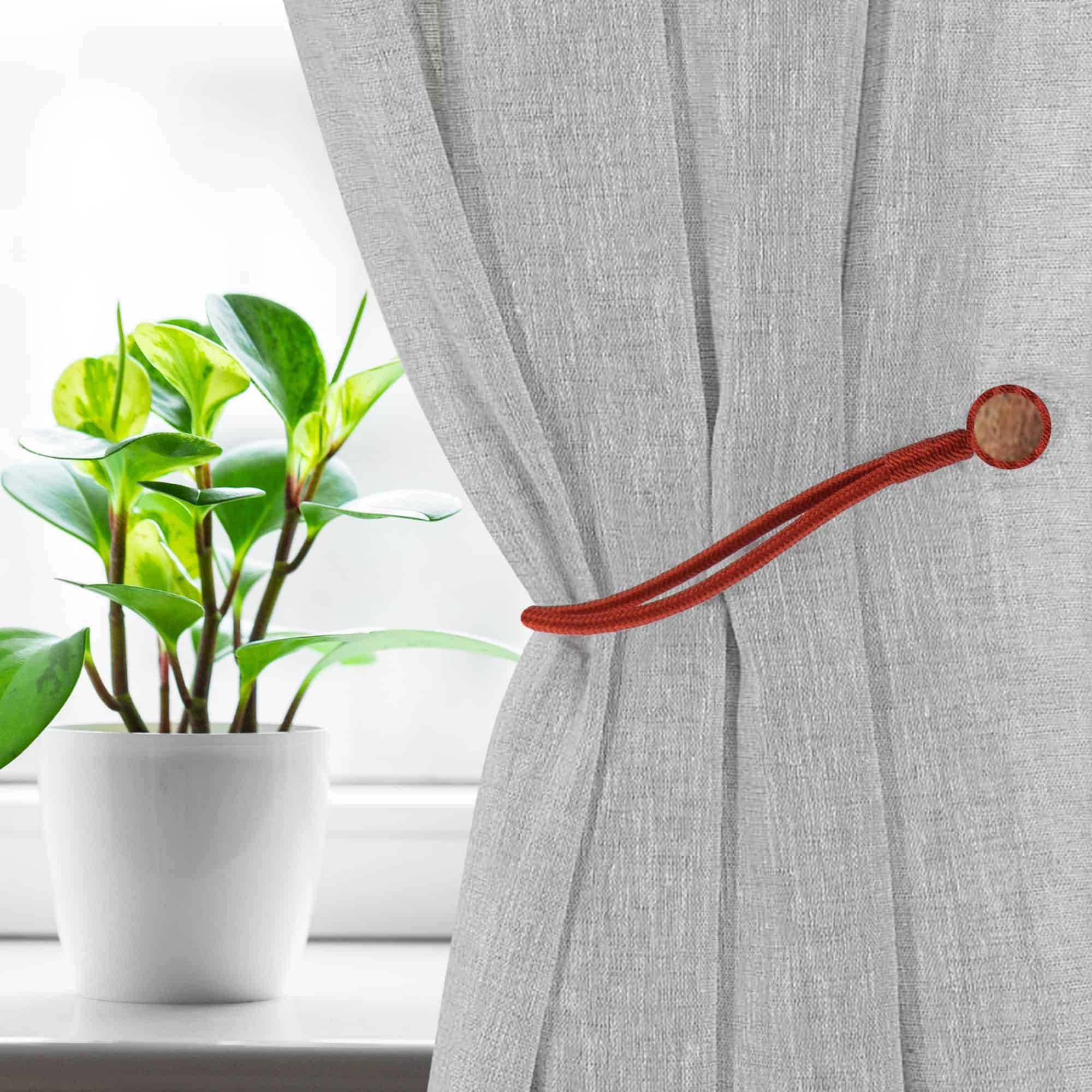 Magnetic Curtain Tieback Holding Gray Curtain – A rust-colored magnetic tieback securing a gray curtain near a window.