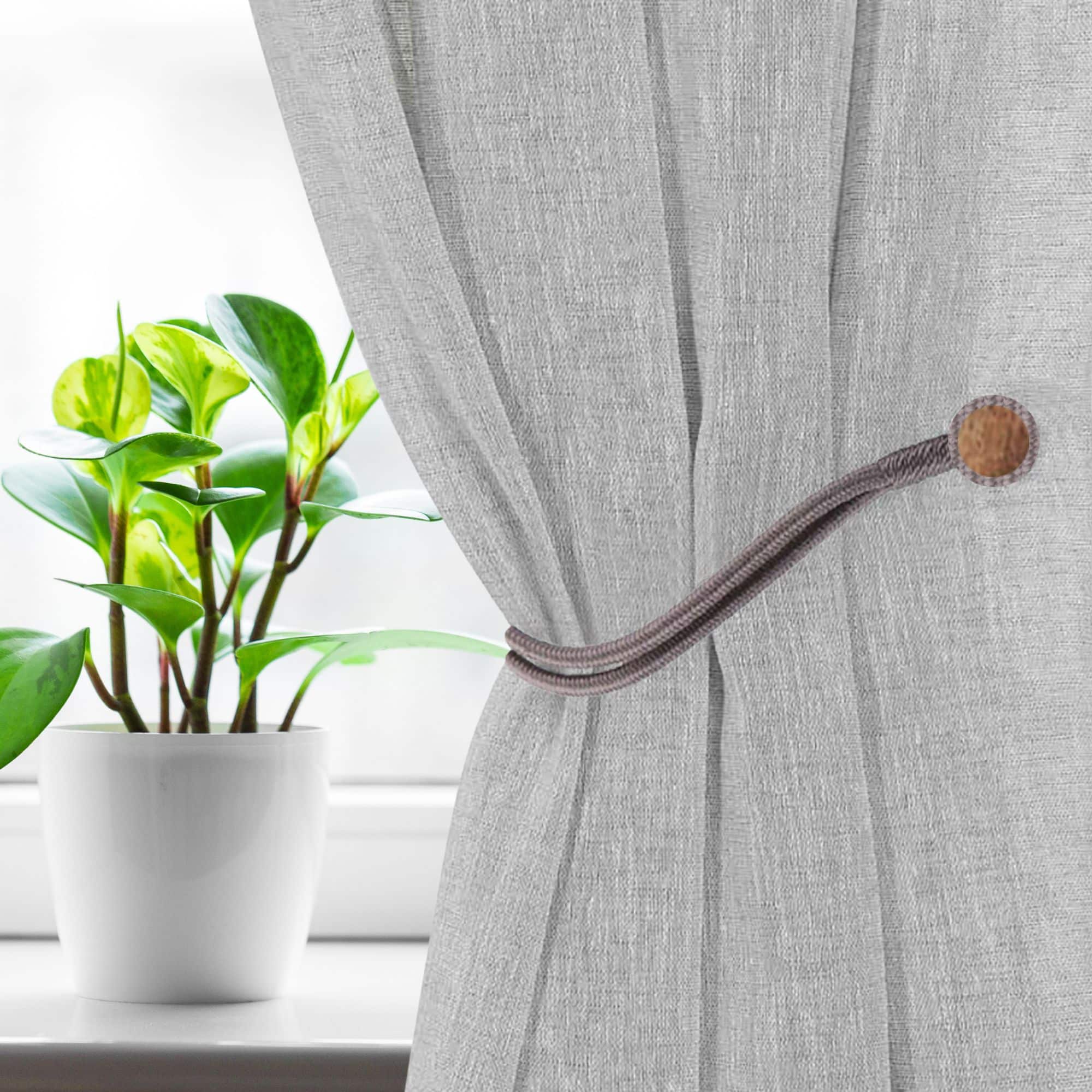 Magnetic Curtain Tieback Holding Gray Curtain – A gray magnetic tieback securing a gray curtain near a window.