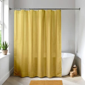 Mustard yellow shower curtain in a bright modern bathroom