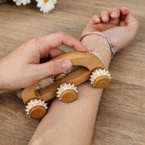 Hand using wooden massage roller on arm for relaxation
