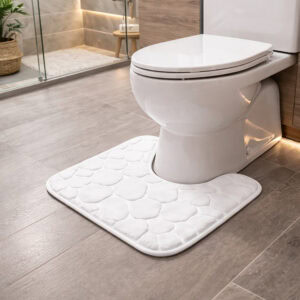 White pebble-embossed memory foam contour mat around toilet, side-angle view in modern bathroom