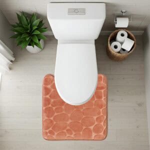 Top-down view of copper pebble-texture contour mat fitted around toilet base