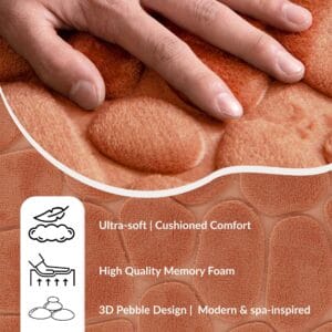 Hand pressing into the soft surface of a copper runner mat with pebble pattern showing cushioned comfort and memory foam features