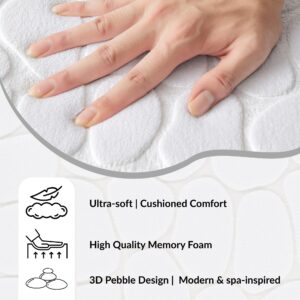 Hand pressing into the soft surface of a white contour mat with pebble pattern showing cushioned comfort and memory foam features