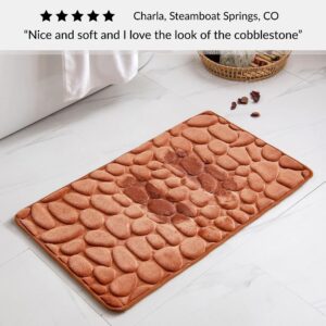Copper bath mat with cobblestone pattern placed near bathtub on bathroom floor with customer review praising softness and design
