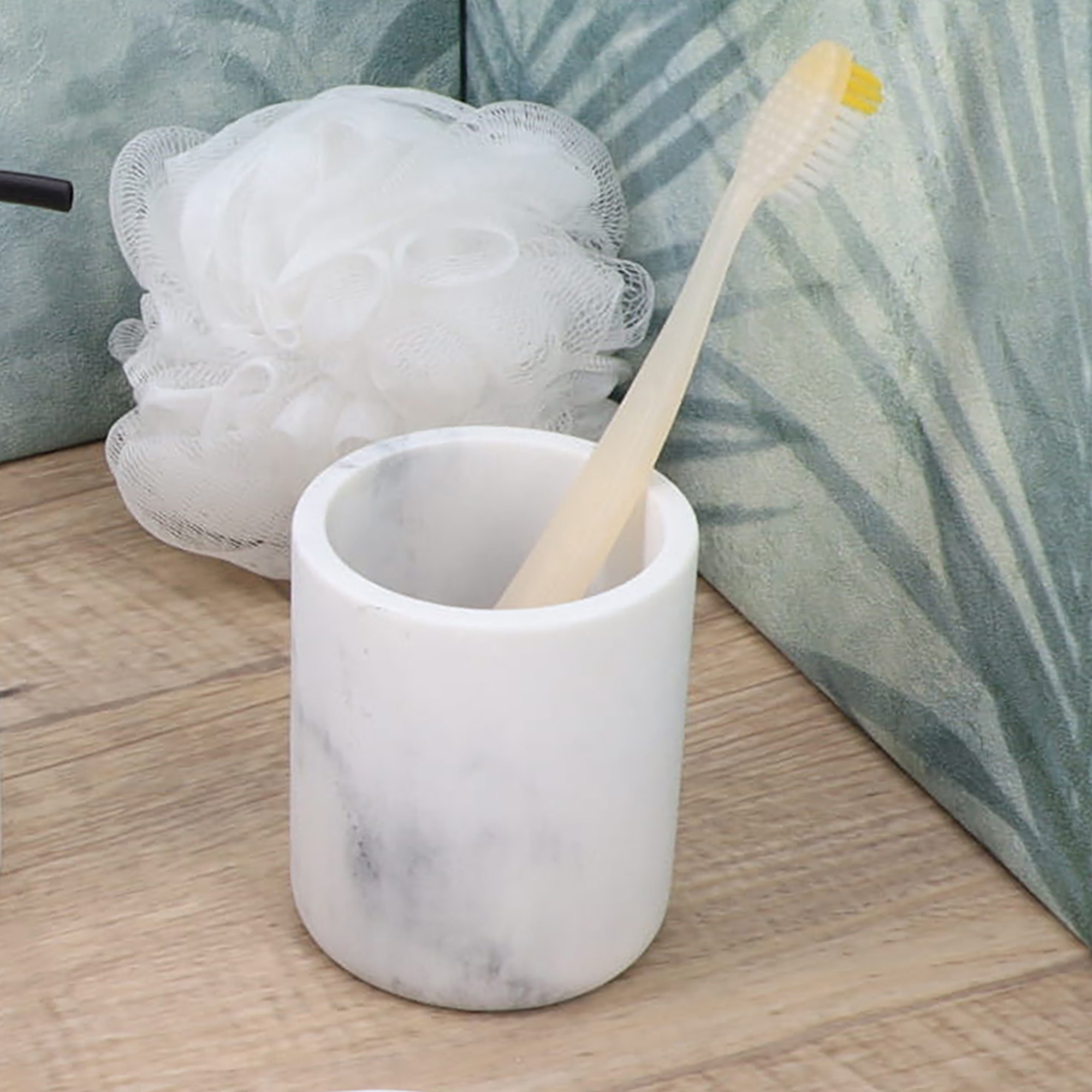 White marble tumbler toothbrush holder on wooden surface