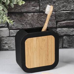 Black toothbrush holder with bamboo front on countertop