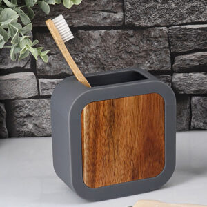Gray toothbrush holder with bamboo front on countertop