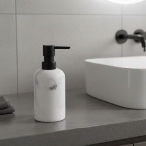 White marble soap dispenser with black pump on modern gray countertop