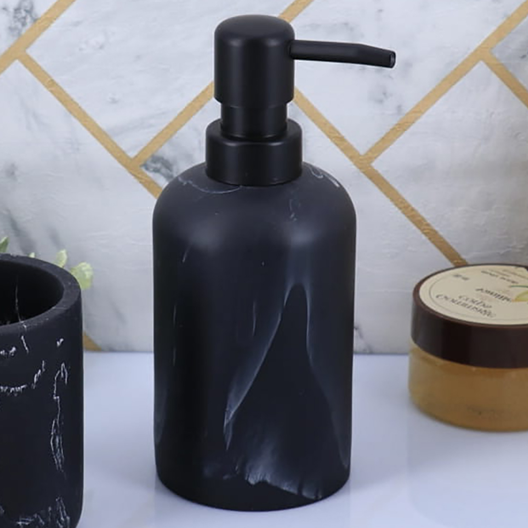 Black marble soap dispenser with black pump close up on bathroom counter