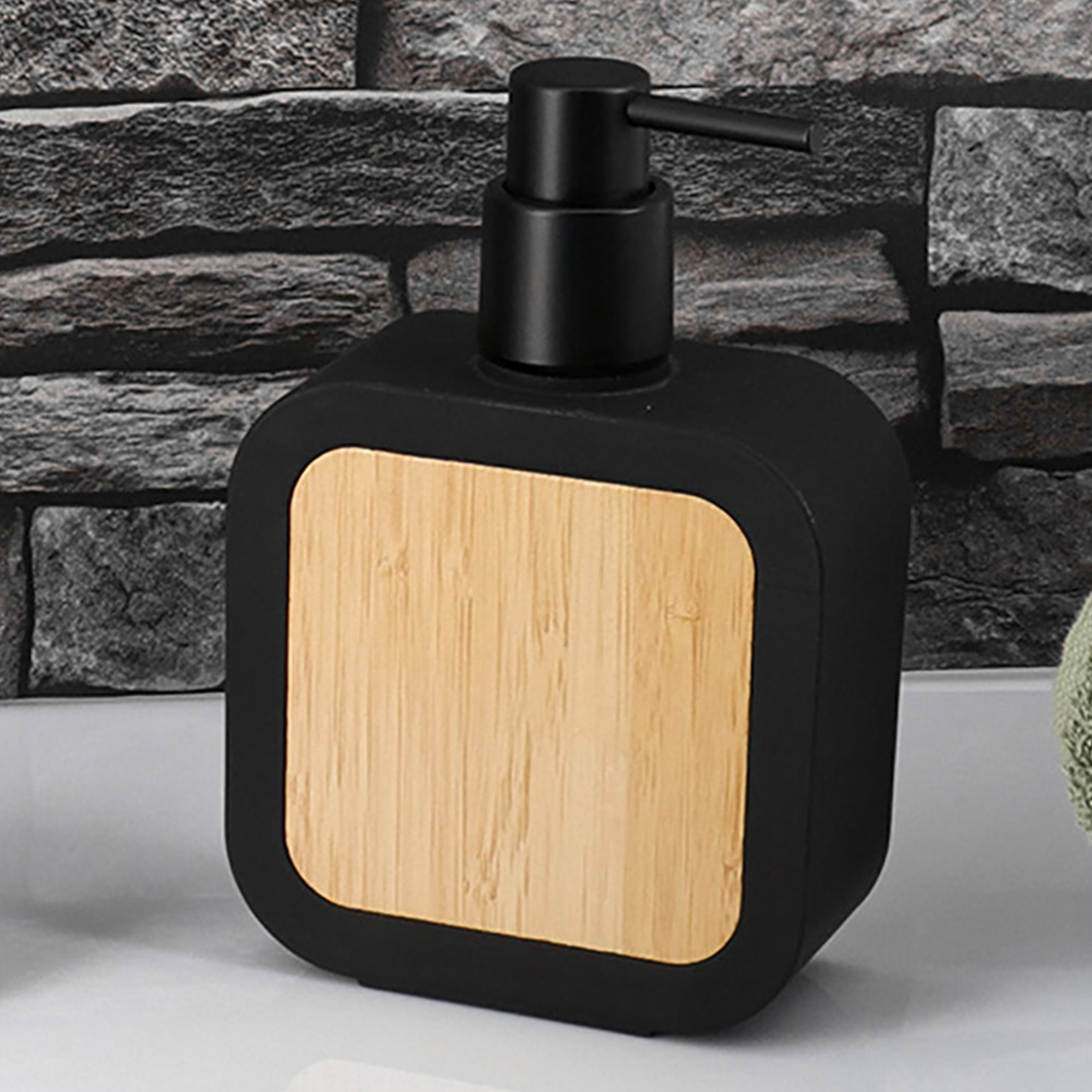 Black soap dispenser with bamboo front panel on countertop, front angle view