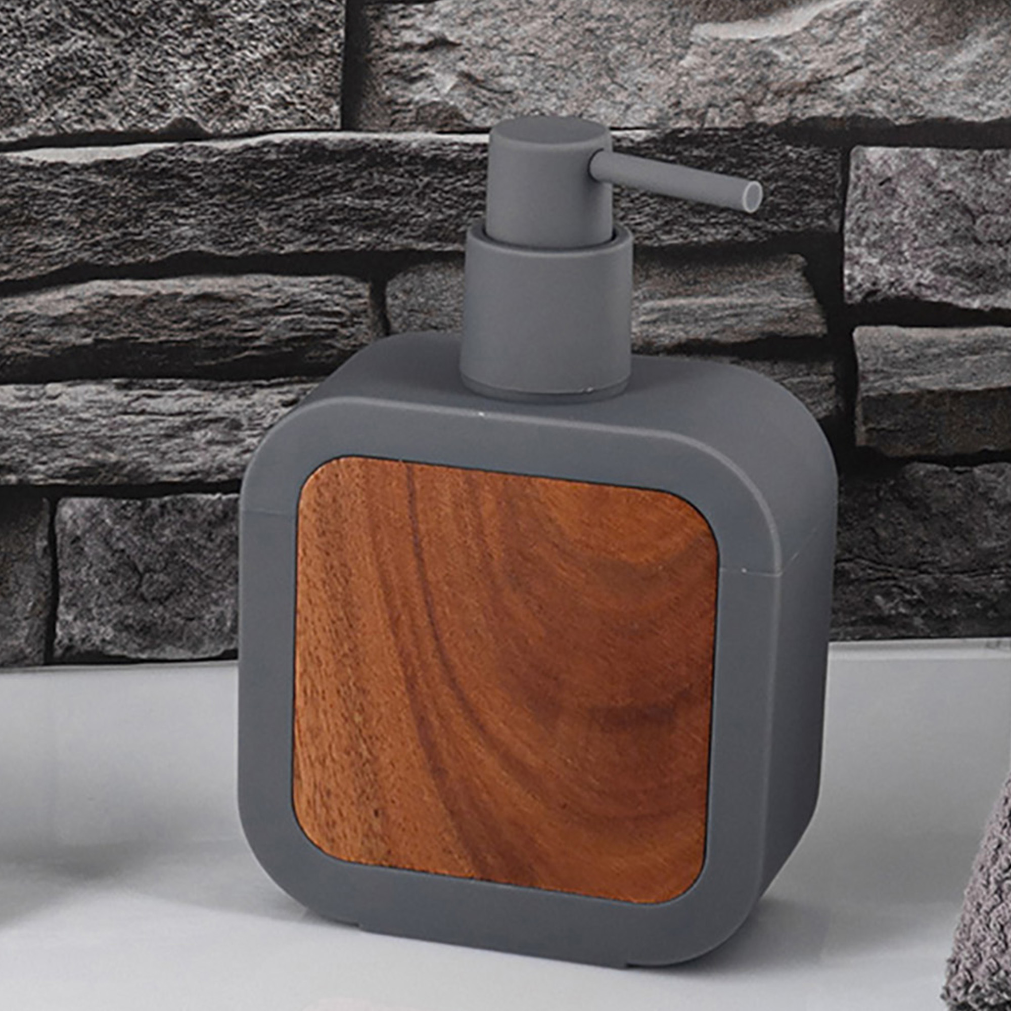 Gray soap dispenser with acacia front panel on countertop, front angle view