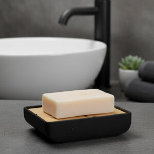 Rectangular bamboo soap tray with black base beside modern sink