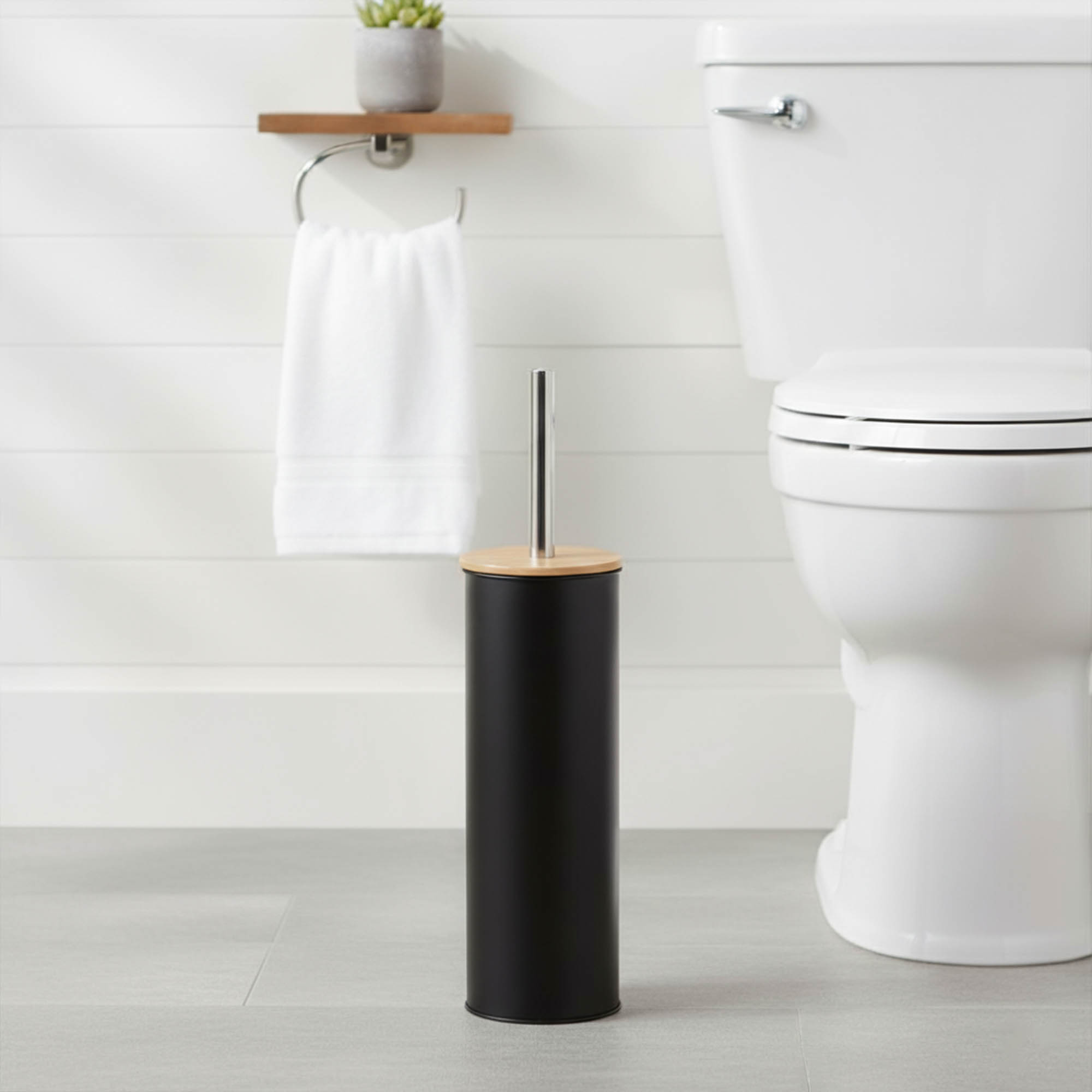 "Modern black toilet brush with bamboo top and stainless steel handle in white bathroom"