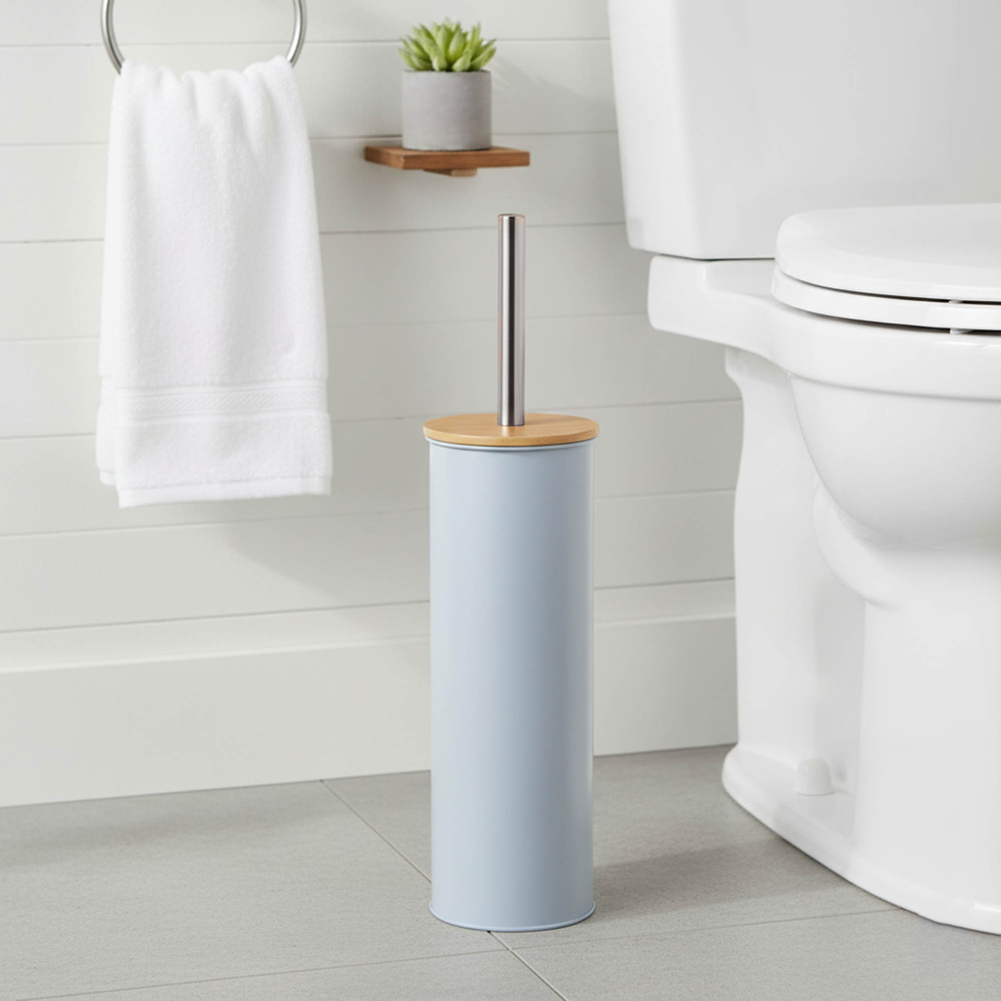 "Modern light blue toilet brush with bamboo top and stainless steel handle in bathroom"