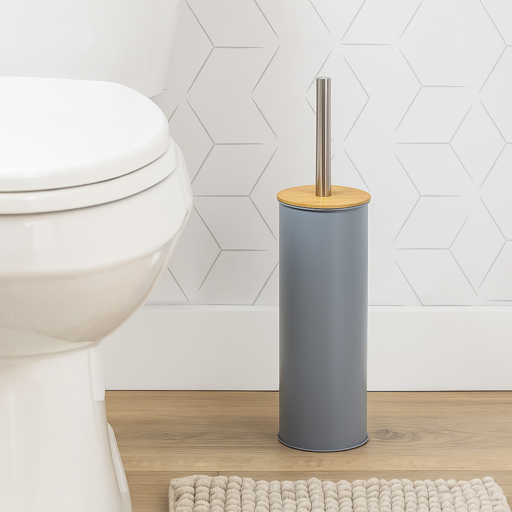 "Gray toilet brush holder with bamboo lid and steel handle beside white toilet"