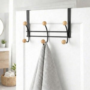 "Matte black over-the-door hook rack with wood ball ends holding gray towel on white bathroom door"
