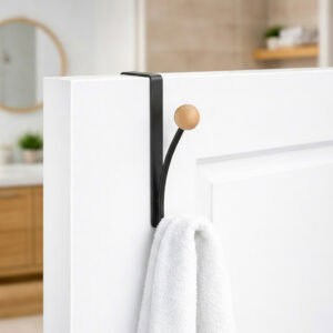 "Matte black over-the-door hook holding white towel on white bathroom door"