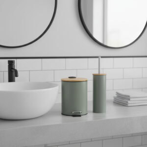 Green trash can and toilet brush with bamboo lids on bathroom counter