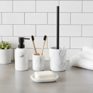 White marble bathroom accessory set with black pump and brush handle, including tumbler, dispenser, soap dish, and toilet brush on countertop