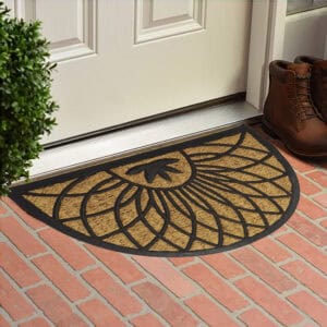 Decorative coco and rubber doormat placed at front door on brick patio