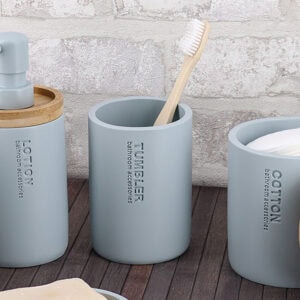 Toothbrush holder tumbler cup on bathroom countertop with toothbrush