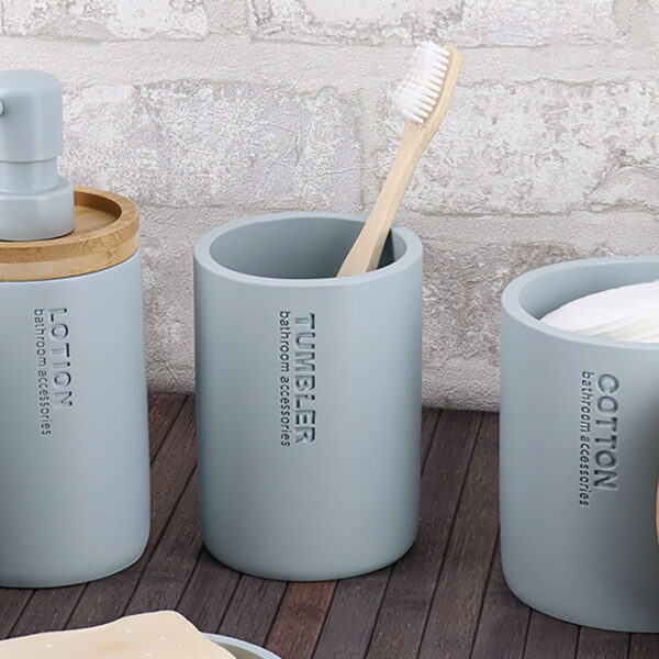 Toothbrush holder tumbler cup on bathroom countertop with toothbrush