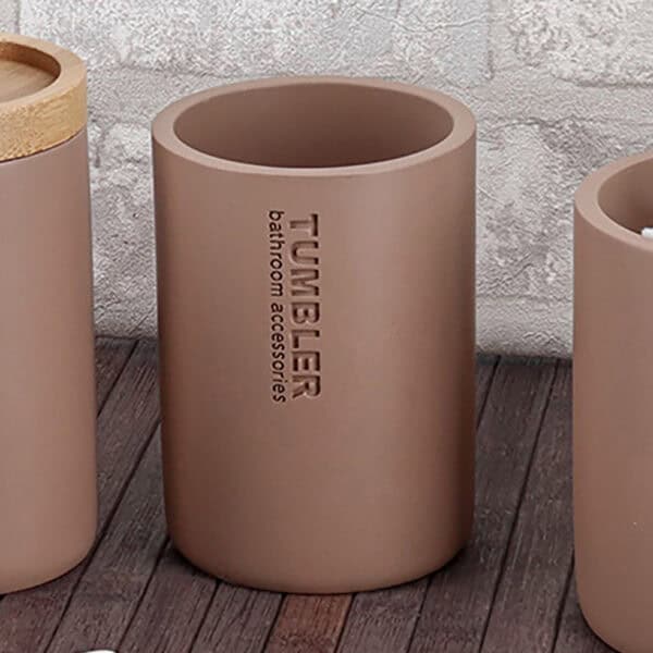 Toothbrush holder tumbler cup on bathroom countertop with toothbrush