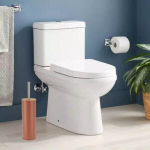 Terracotta toilet brush placed in clean bathroom with blue walls, next to white toilet