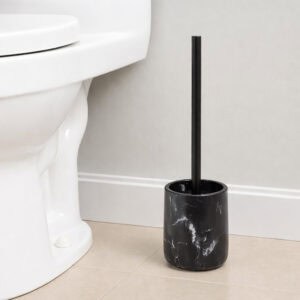 Black marble toilet brush holder with black handle next to white toilet