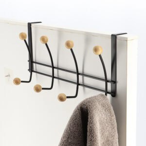 "Black 4-hook rack with wood ball ends mounted on white door holding gray towel"