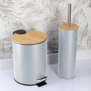“Light blue trash can and toilet brush with bamboo lids against patterned bathroom wall”