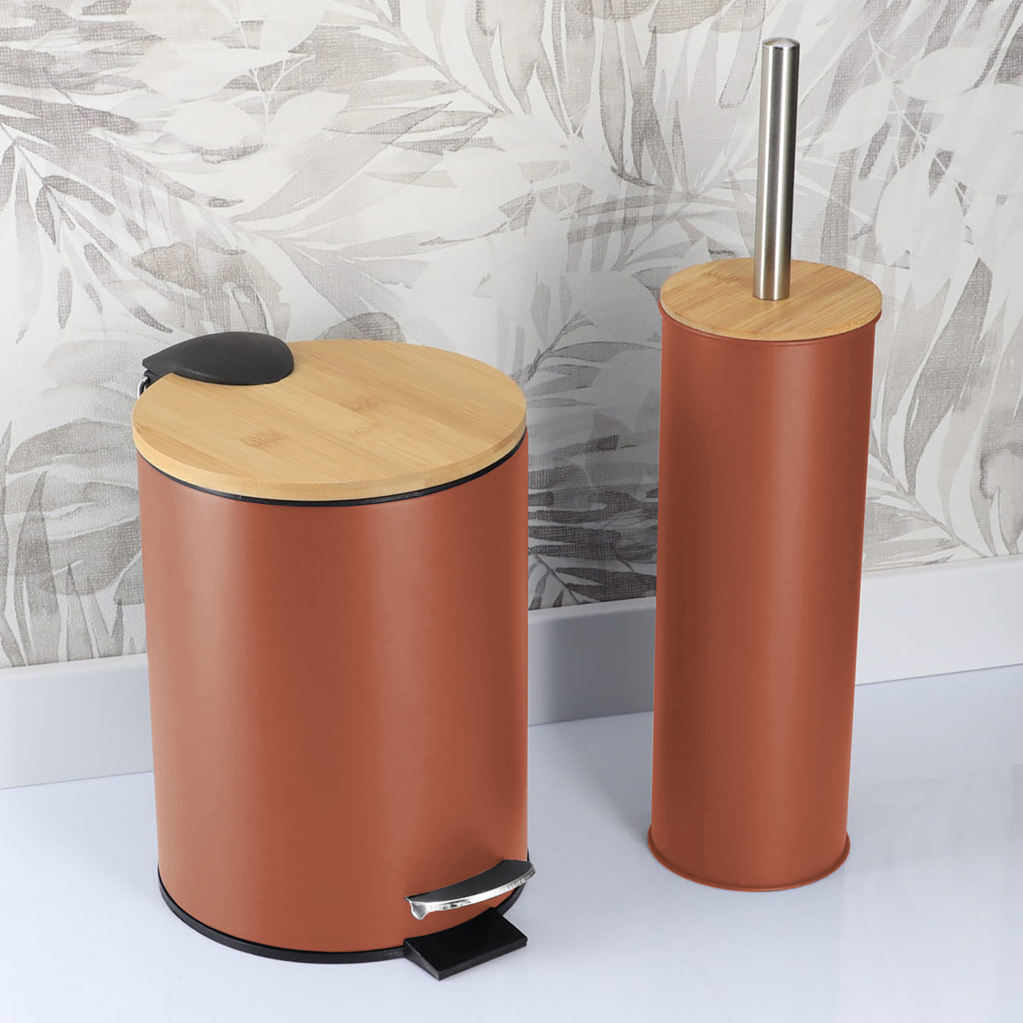 Terracotta bathroom trash bin and toilet brush holder in a bathroom with patterned wall background