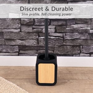 Discreet toilet brush with bamboo insert displayed on wood floor and stone wall background