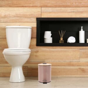 Compact cappuccino bin with foot pedal next to toilet in bathroom