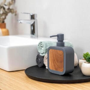Soap dispenser in use by sink with matching accessories
