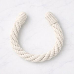 "Chalk white twisted rope tieback in U-shape on marble surface"