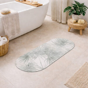 Oval runner bath mat with light gray palm leaf pattern on a bathroom floor next to a freestanding tub, woven stool with plant, wicker basket with towels, and jute rug.