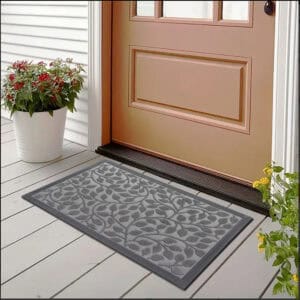 Gray rubber doormat placed at front door with flowers and siding
