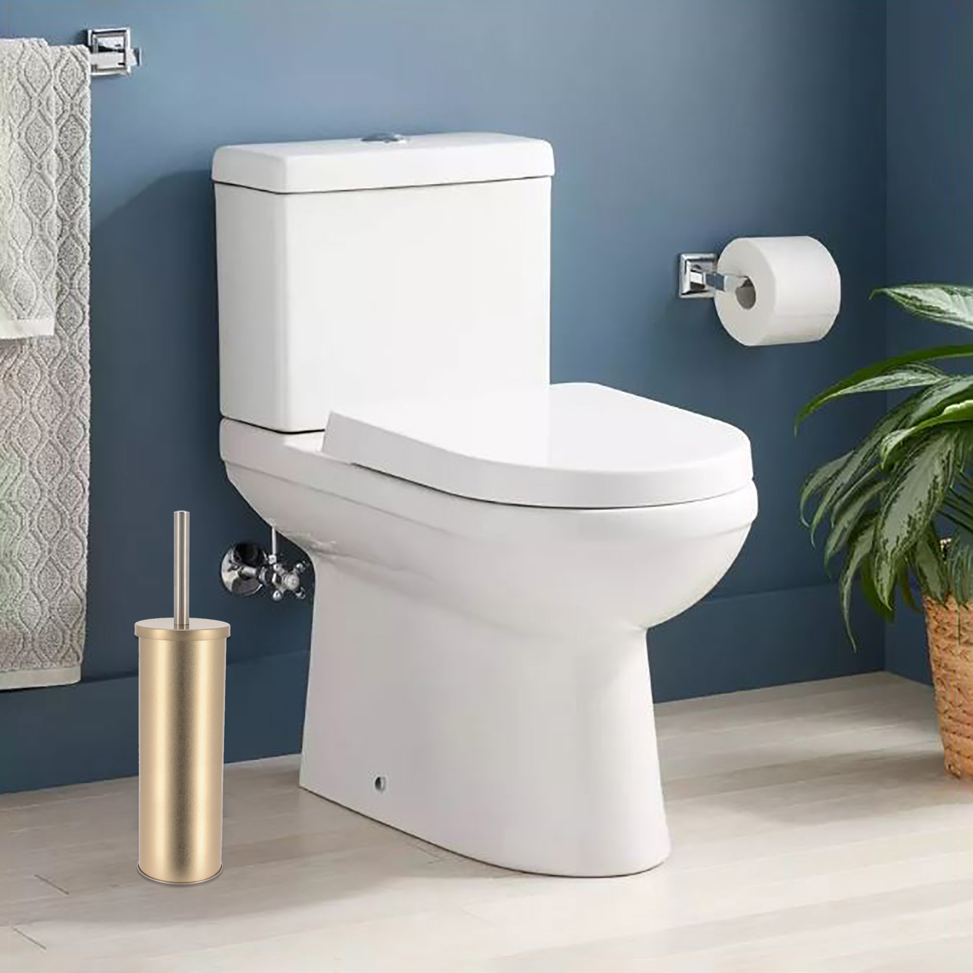 Toilet brush holder in brushed gold placed beside a modern white toilet