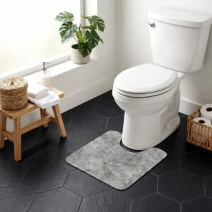 Urban Concrete contour mat styled around toilet in bright bathroom with monstera plant and wicker accents