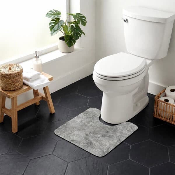 Urban Concrete contour mat styled around toilet in bright bathroom with monstera plant and wicker accents