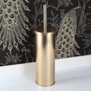 Stylish gold toilet brush set against black and gold peacock wallpaper